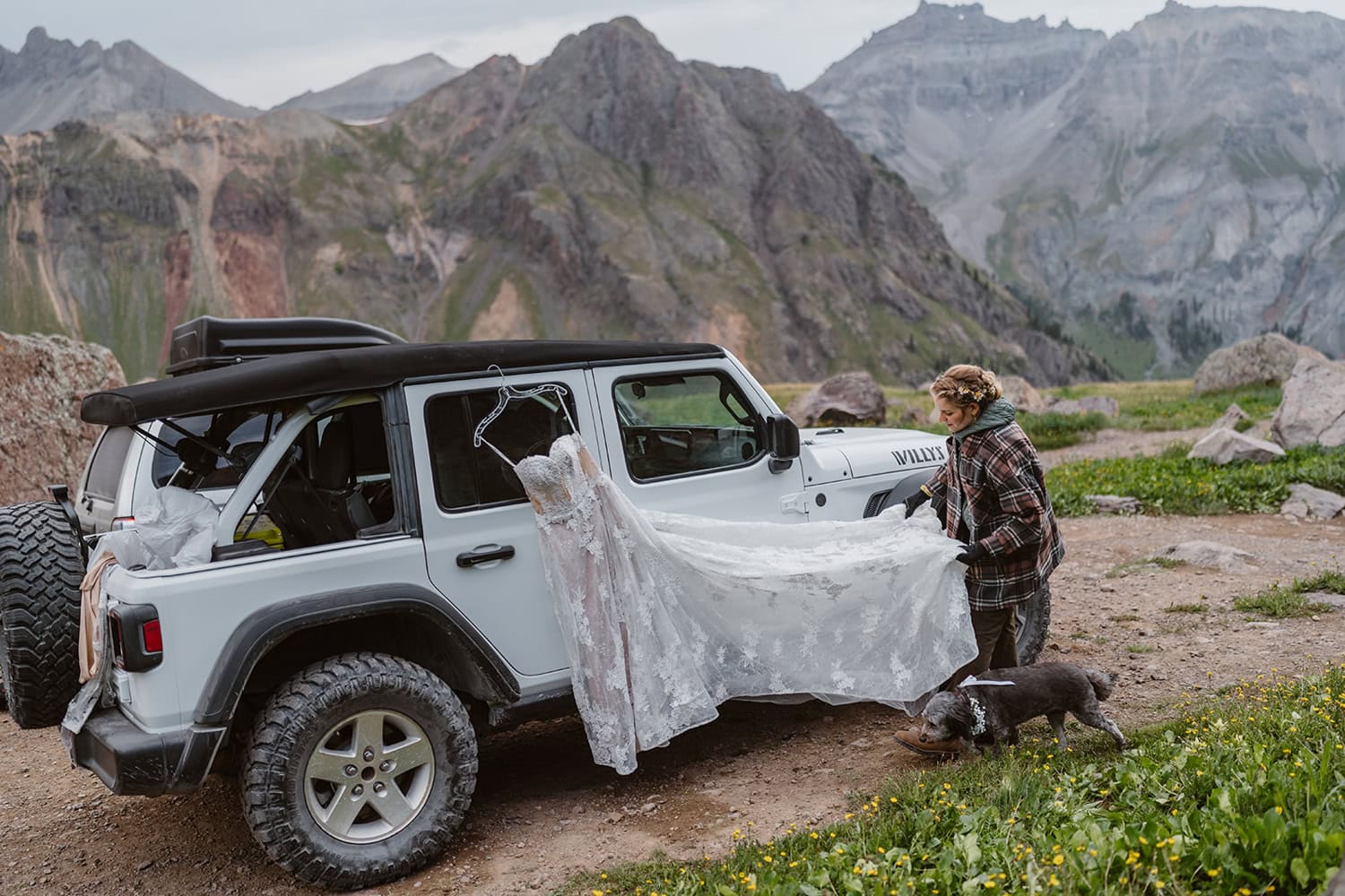 Bride getting ready at her jeep for her off roading elopement.