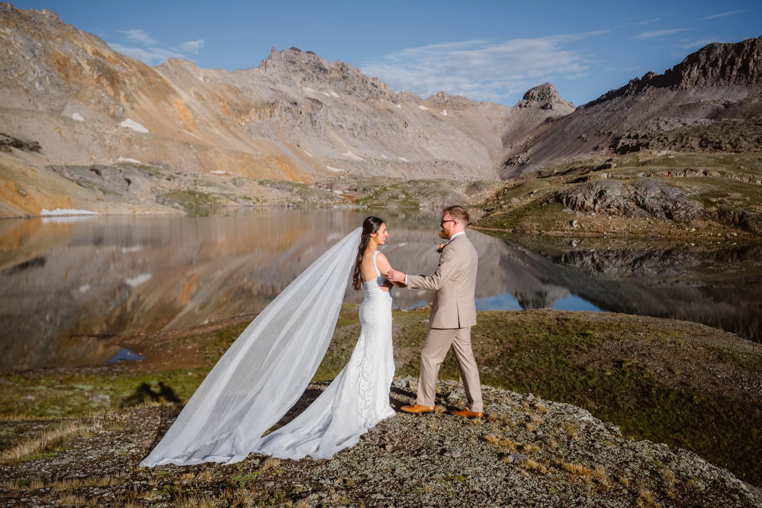 San Juan Mountain elopement Couple standing near an alpine lake in the San Juan mountains for their elopement.