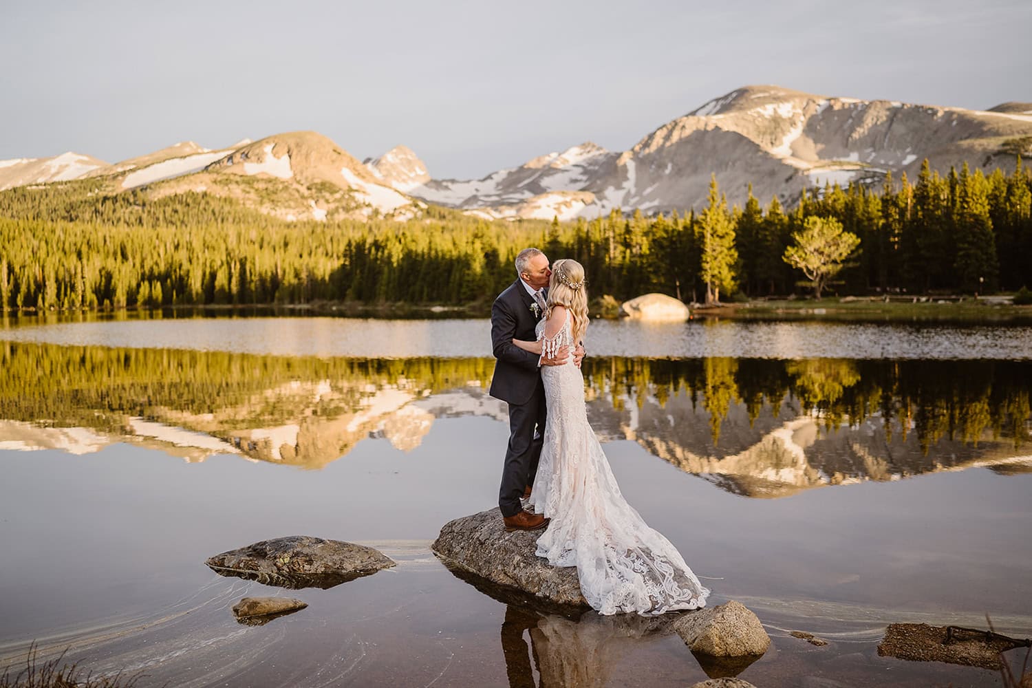 Bride and groom kissing at a rock near Brainard Lake for their elopement.